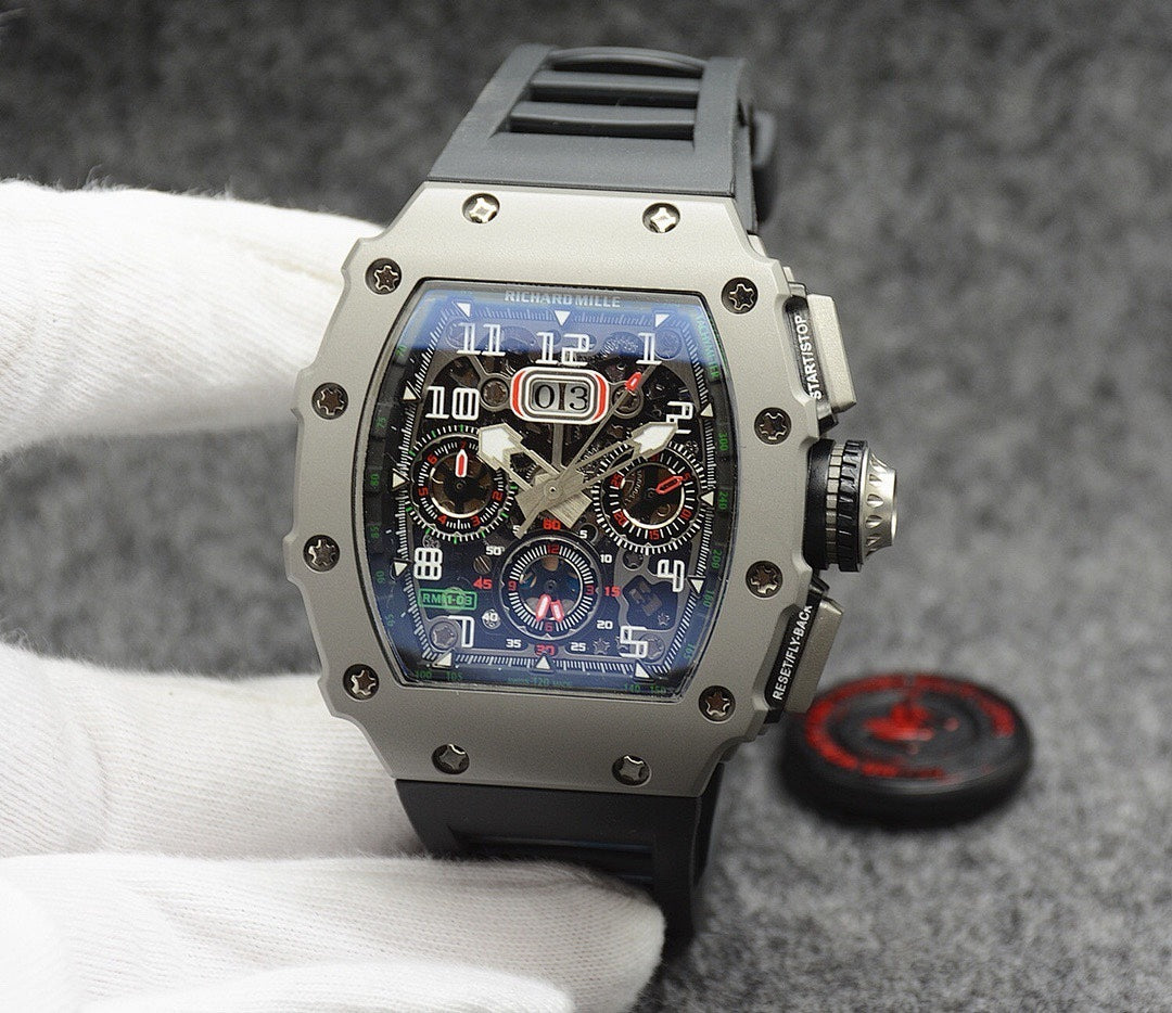 Richard Mille watch with silver case, blue dial, and black rubber strap