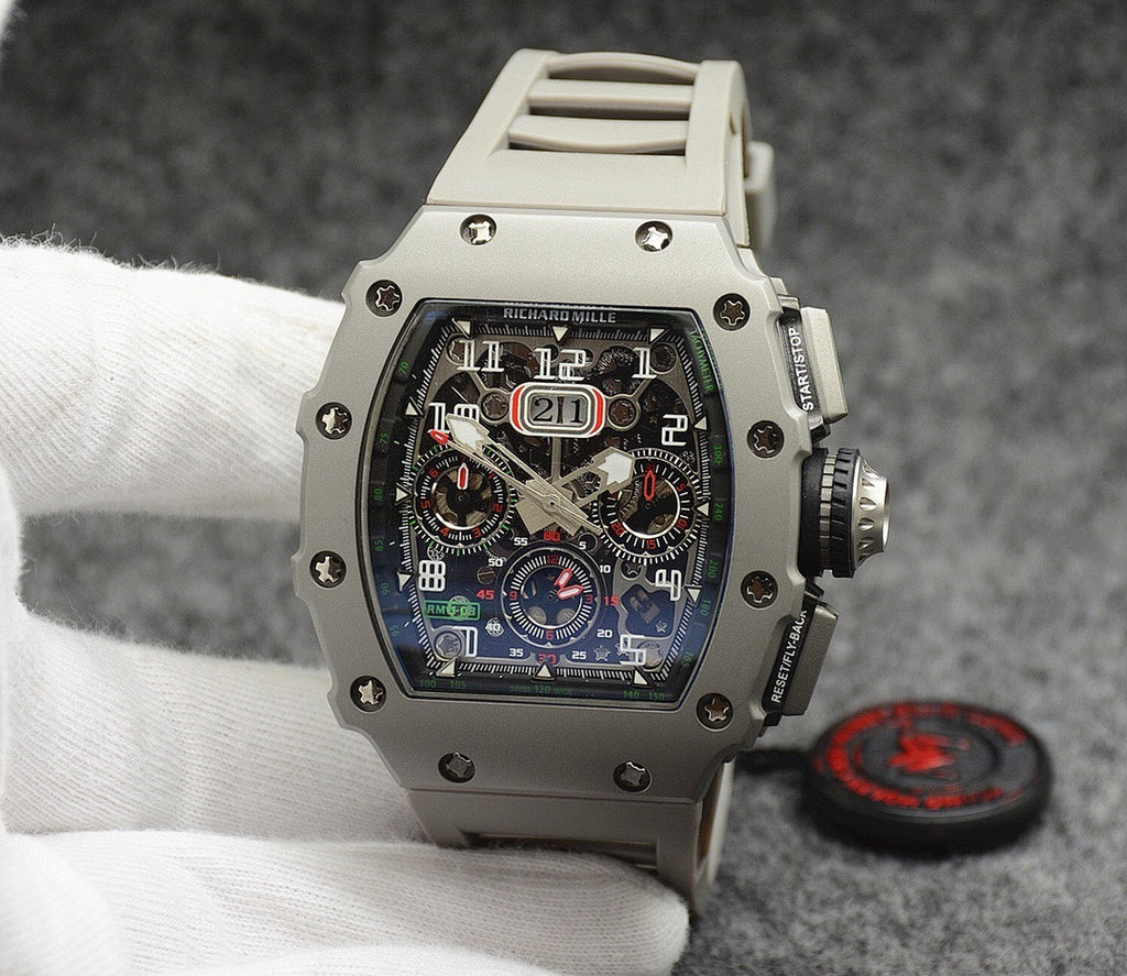 Richard Mille watch with silver case, black dial, and light gray rubber strap