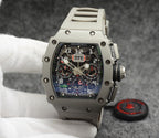 Richard Mille watch with silver case, black dial, and light gray rubber strap