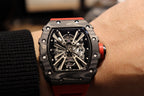 Richard Mille watch front view with black case, skeletal dial, and red rubber strap