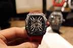 Richard Mille watch with black octagonal case and skeletal dial on red strap