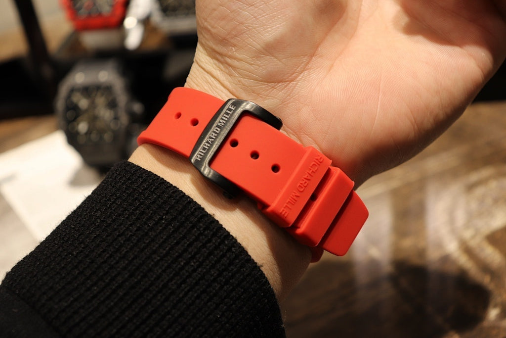 Richard Mille watch with red silicone strap and black buckle on wrist