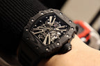 Richard Mille watch on wrist, close-up of black skeleton dial and metal starburst hands