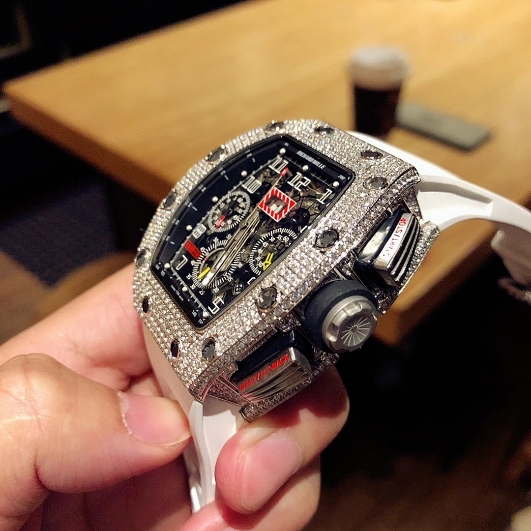Square luxury watch side view with dark dial, jeweled bezel, and white rubber strap
