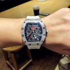 Square luxury watch on wrist, dark dial with colorful subdials, jeweled bezel, white strap