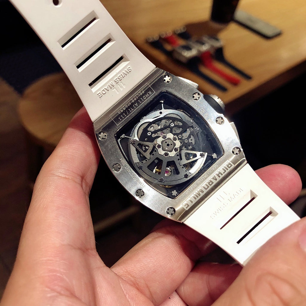 Watch caseback with exposed mechanical movement and white rubber strap