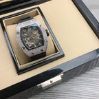 Richard Mille watch in box, silver diamond bezel, black strap, blue skeleton dial