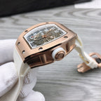 Richard Mille watch on white strap, rose-gold case side view with crown.