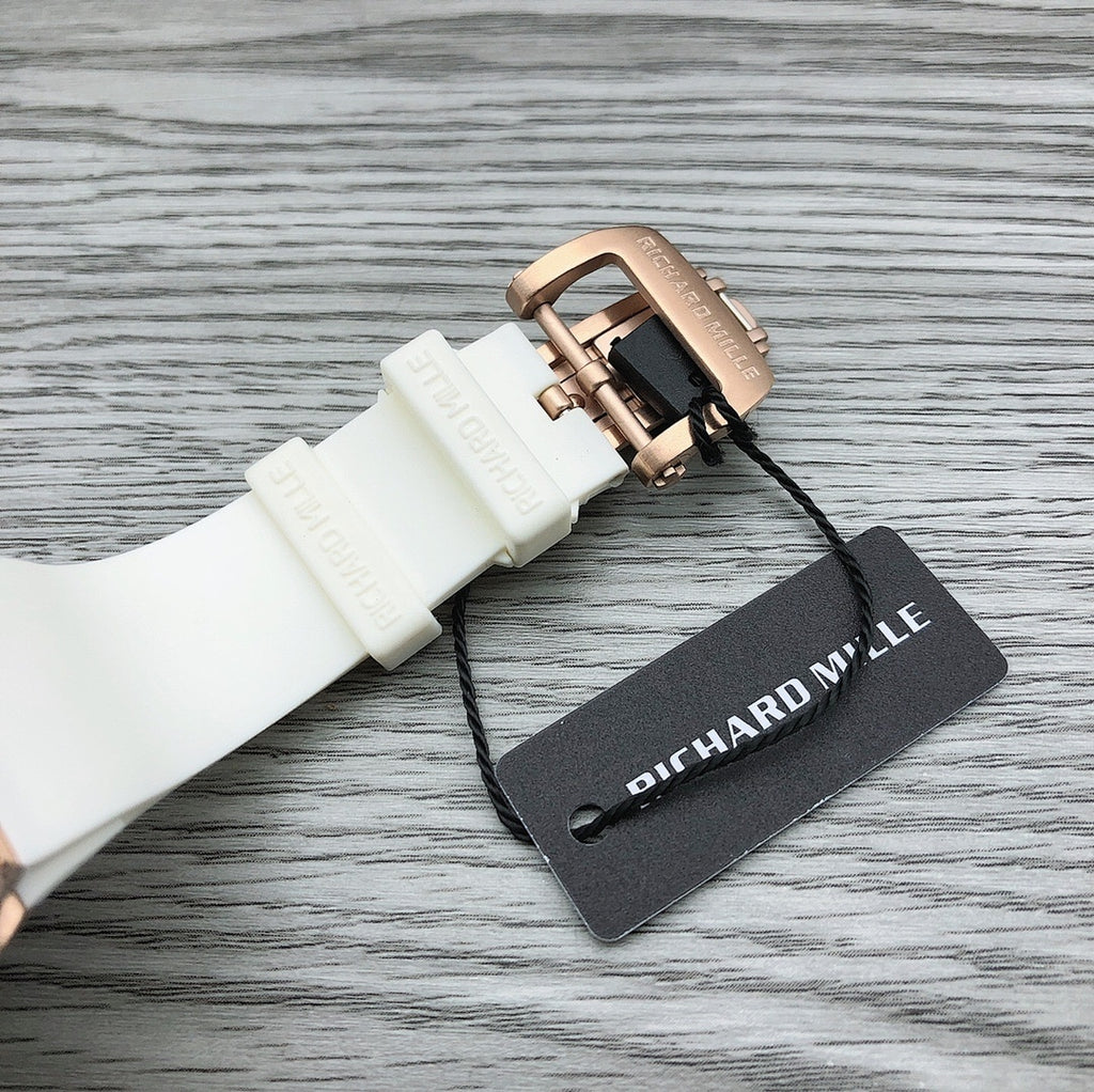 White rubber watch strap with rose-gold buckle and Richard Mille hang tag.