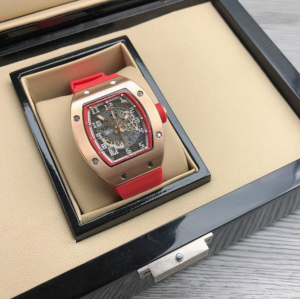Richard Mille watch in open box, rose-gold case with red strap and skeleton dial.