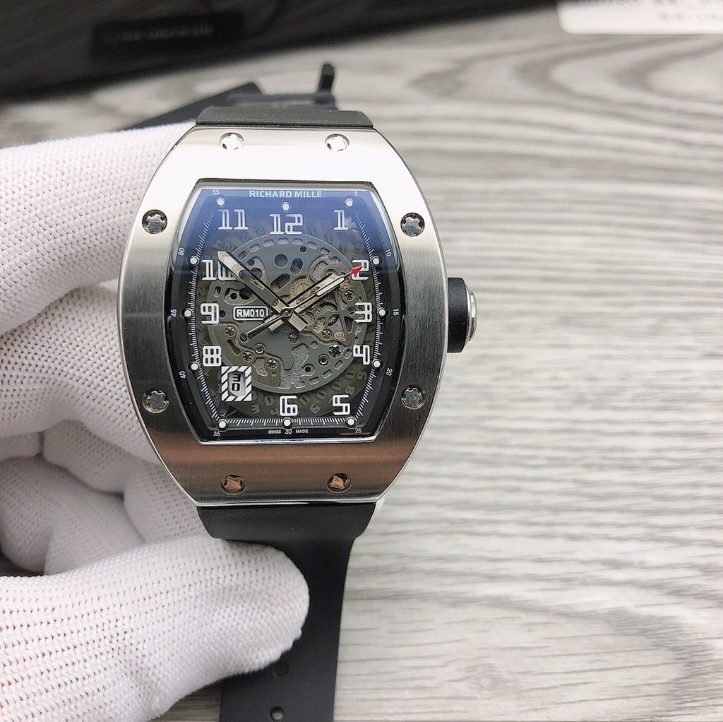 Richard Mille watch with silver case, black dial, and black rubber strap.