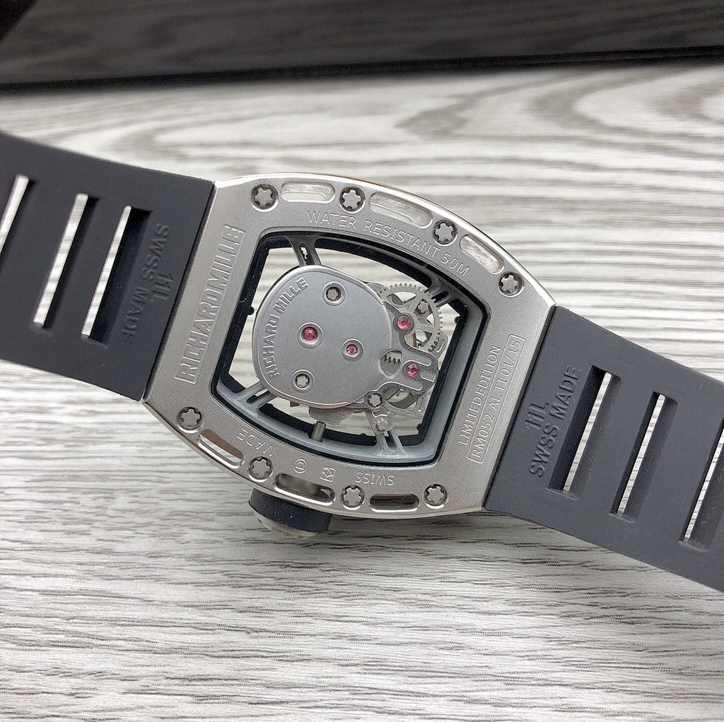 Angle view of skeleton watch with silver case and black strap, detailed dial window