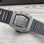 Angle view of skeleton watch with silver case and black strap, detailed dial window