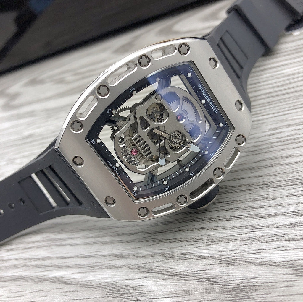 Silver-toned sport watch with black strap and clear dial showing visible mechanics