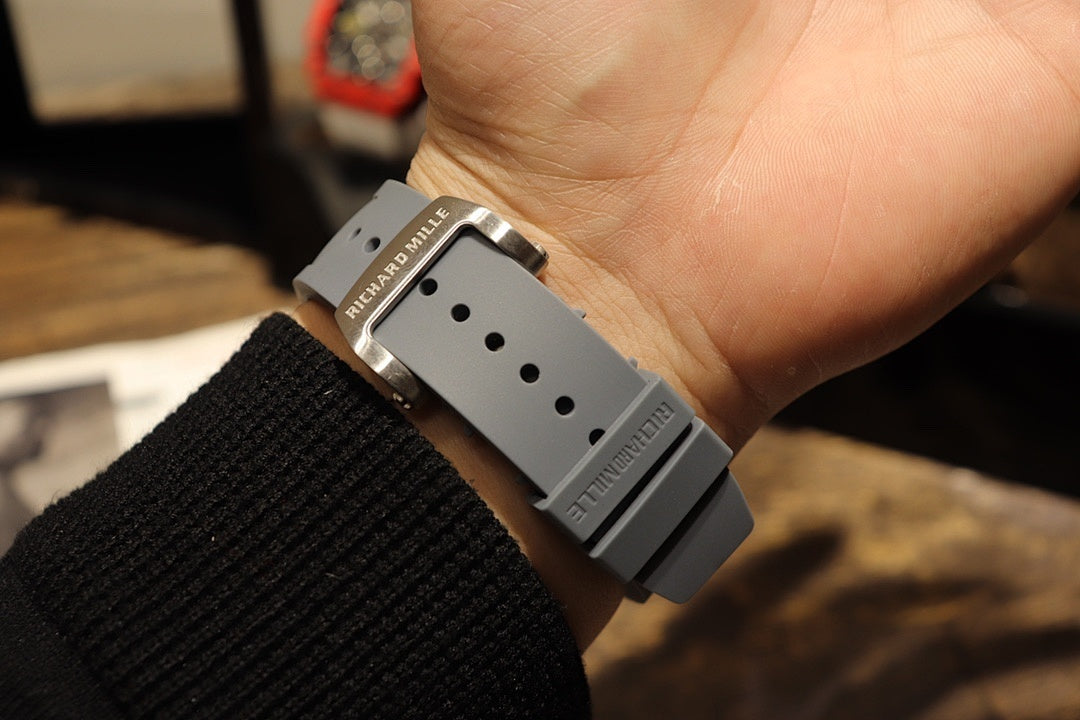 Richard Mille wristwatch with perforated gray strap on wrist