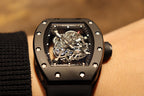 Black skeleton wristwatch, close-up of exposed gears in square dial