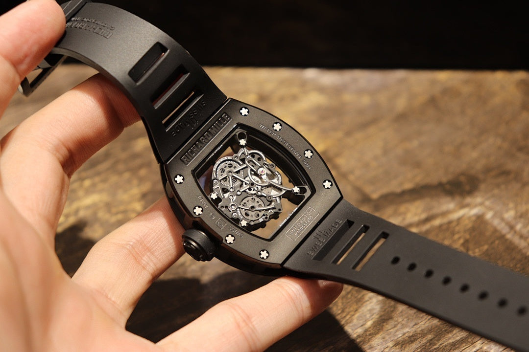 Black rubber strap watch from side, square bezel with exposed movement