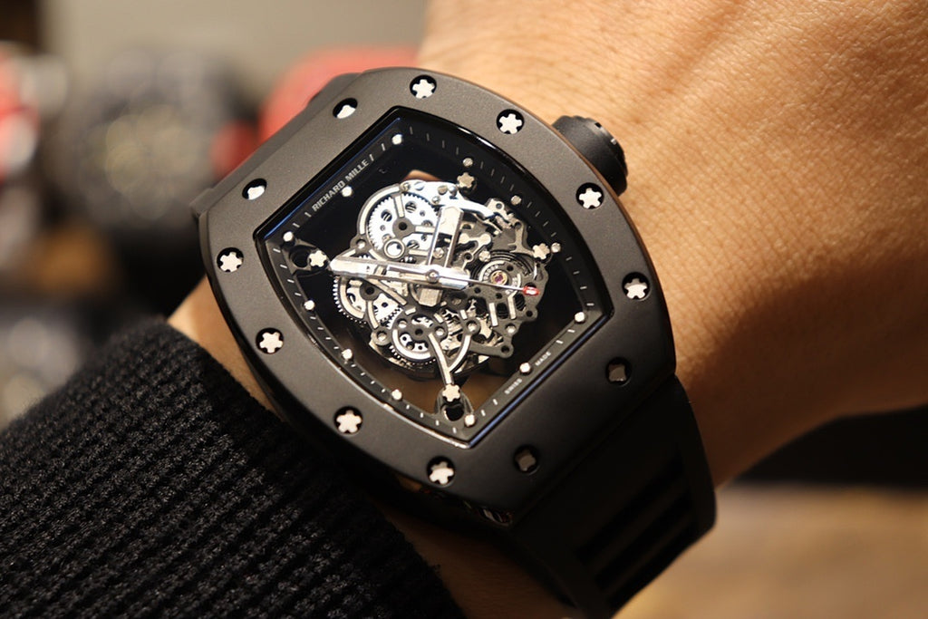 Black skeleton wristwatch close-up on wrist with visible mechanical movement