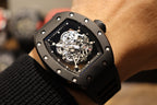 Black skeleton wristwatch close-up on wrist with visible mechanical movement
