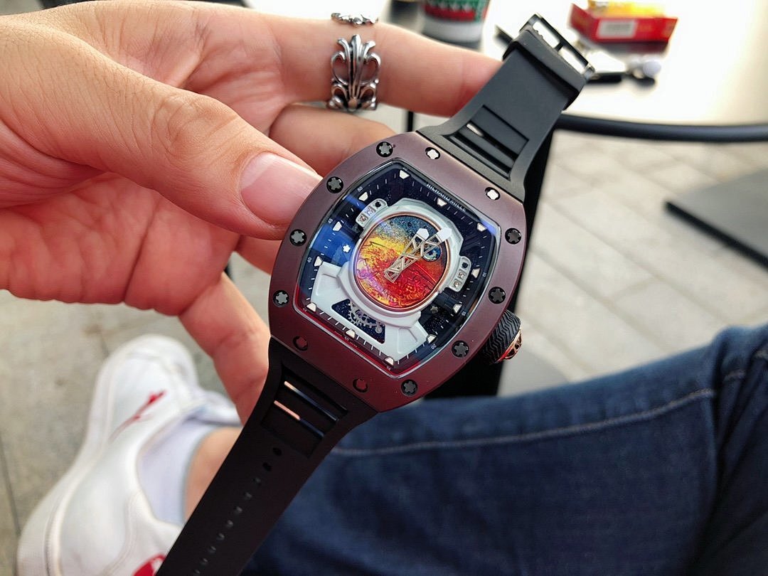 Richard Mille watch close-up, burgundy case and black rubber strap, openwork dial