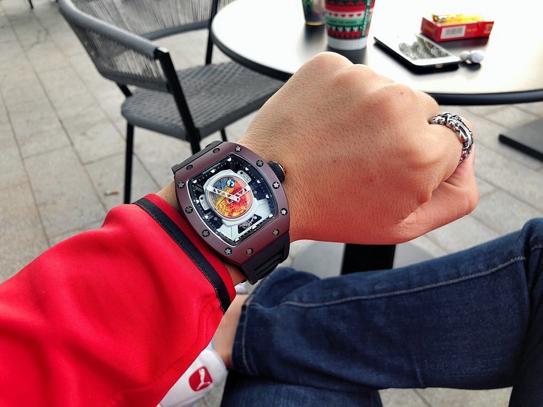Richard Mille timepiece on wrist, burgundy case and black strap, skeleton dial