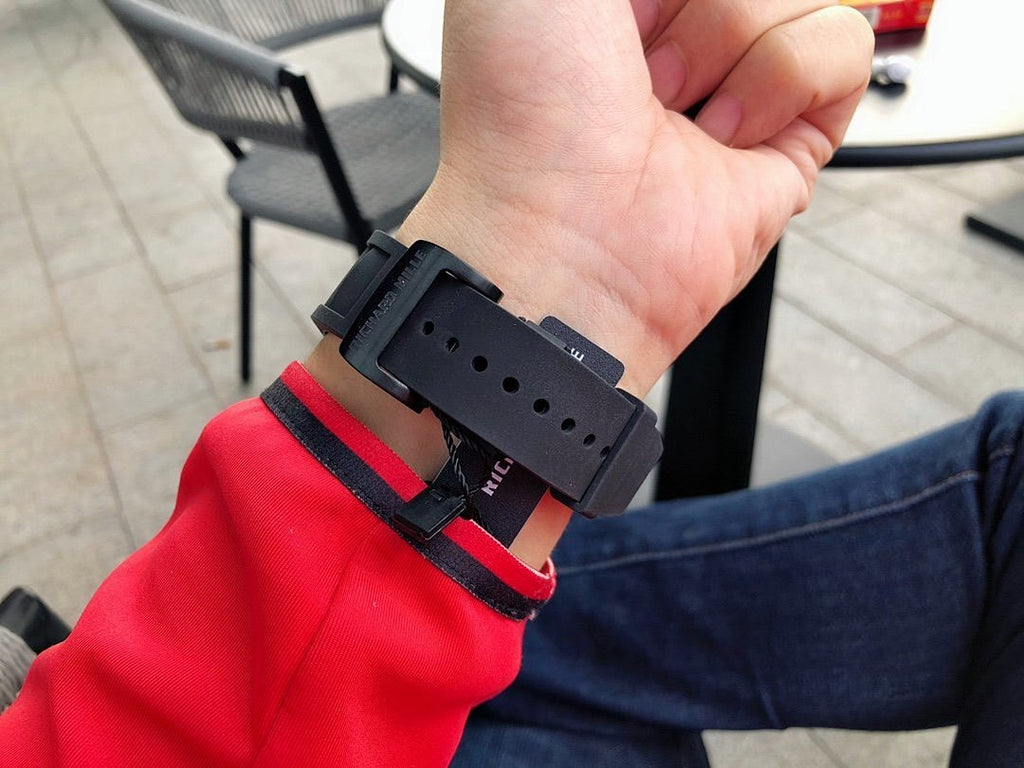 Richard Mille watch rear view, black rubber strap with folding clasp and red accent