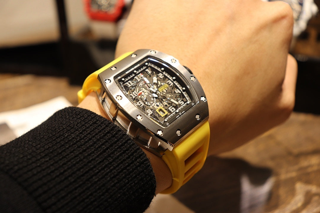Richard Mille wristwatch with yellow strap and black skeleton face, viewed at an angle.