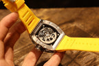 Richard Mille wristwatch side view: yellow strap with black caseback and silver screws.