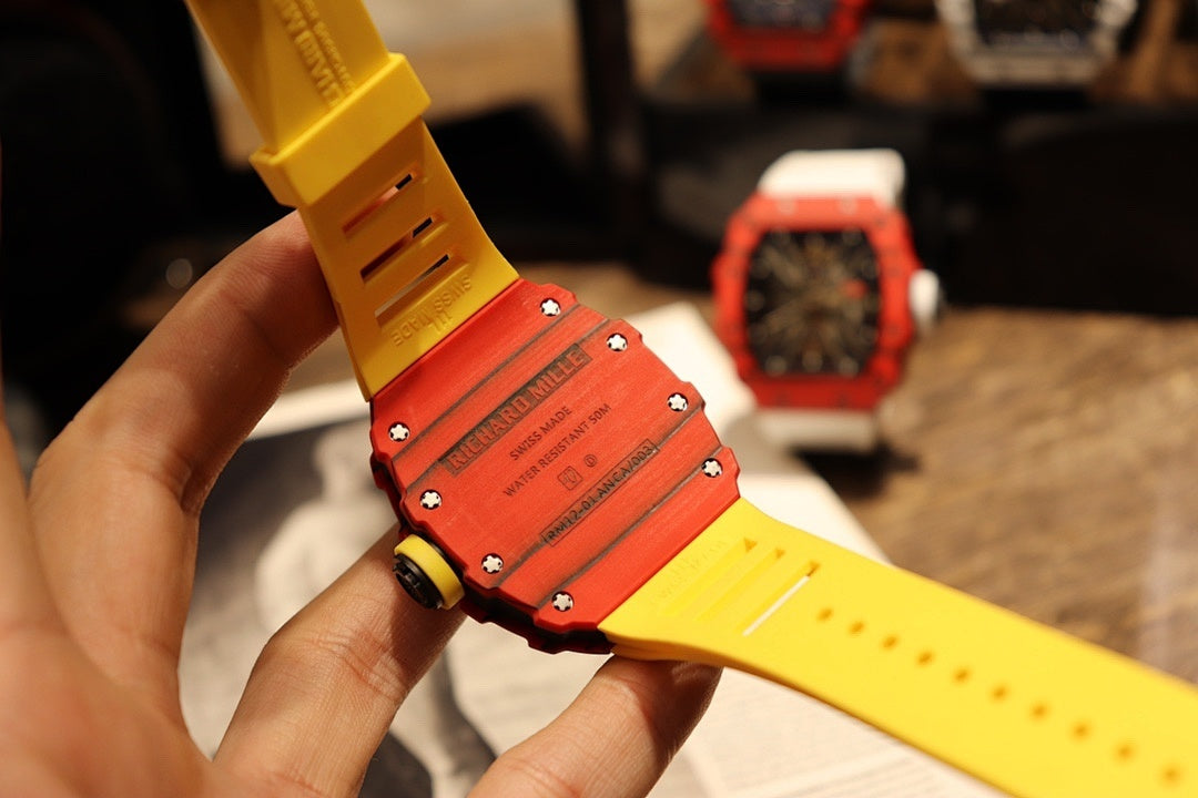 Yellow rubber watch strap with red case back and visible screws