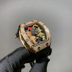 Gold-toned wristwatch with jeweled bezel, colorful skeleton dial, and black strap
