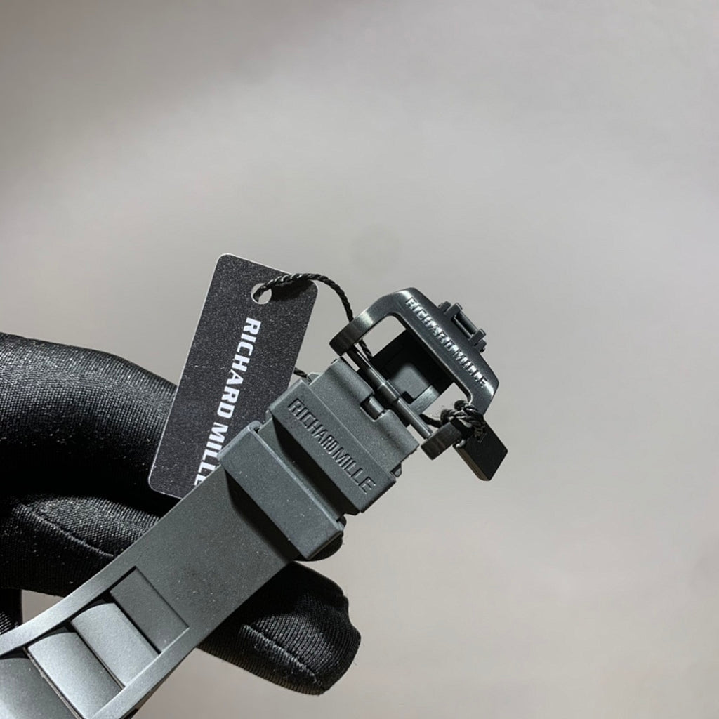 Wristwatch strap with black metal clasp and hanging Richard Mille tag