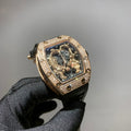 Gold-toned wristwatch with jeweled bezel, skeleton dial, and black strap