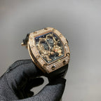 Gold-toned wristwatch with jeweled bezel, skeleton dial, and black strap