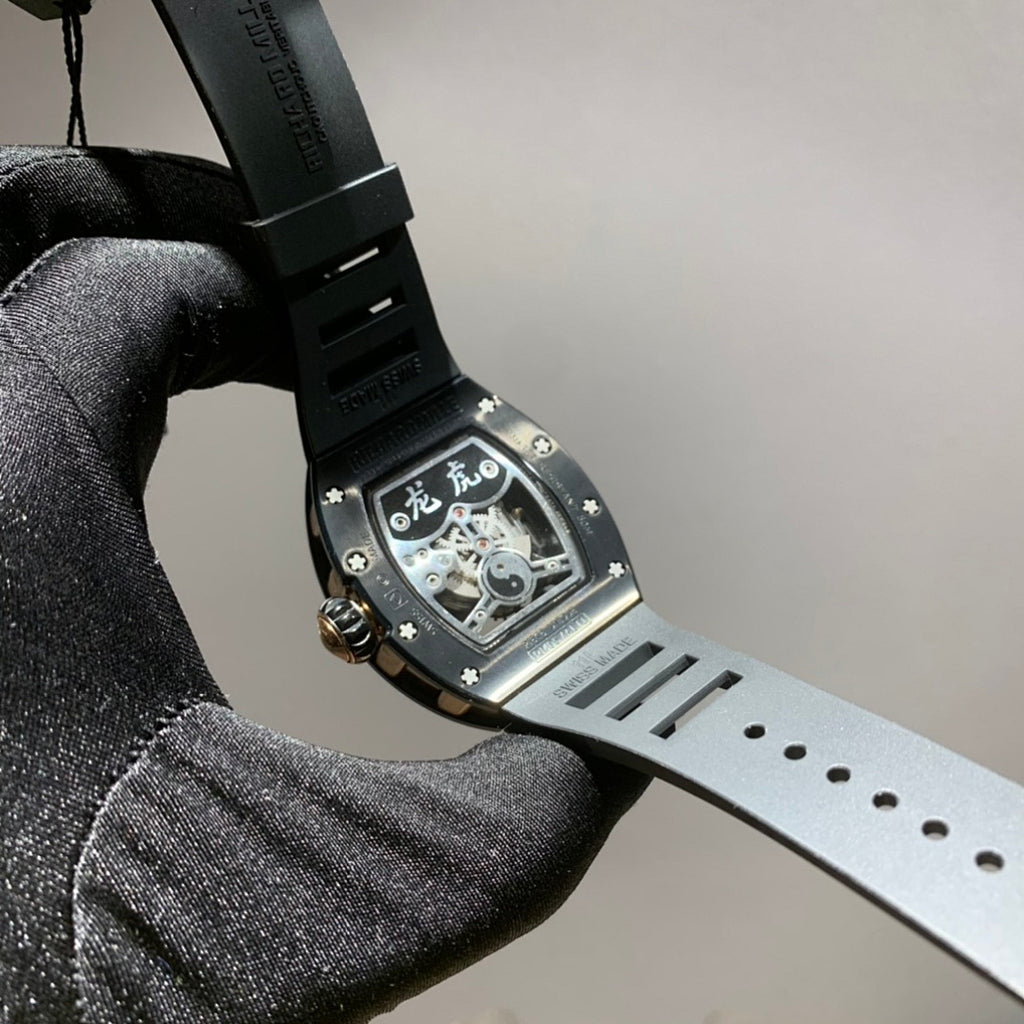 Richard Mille watch with dark dial, light gray strap, and skeleton movement visible
