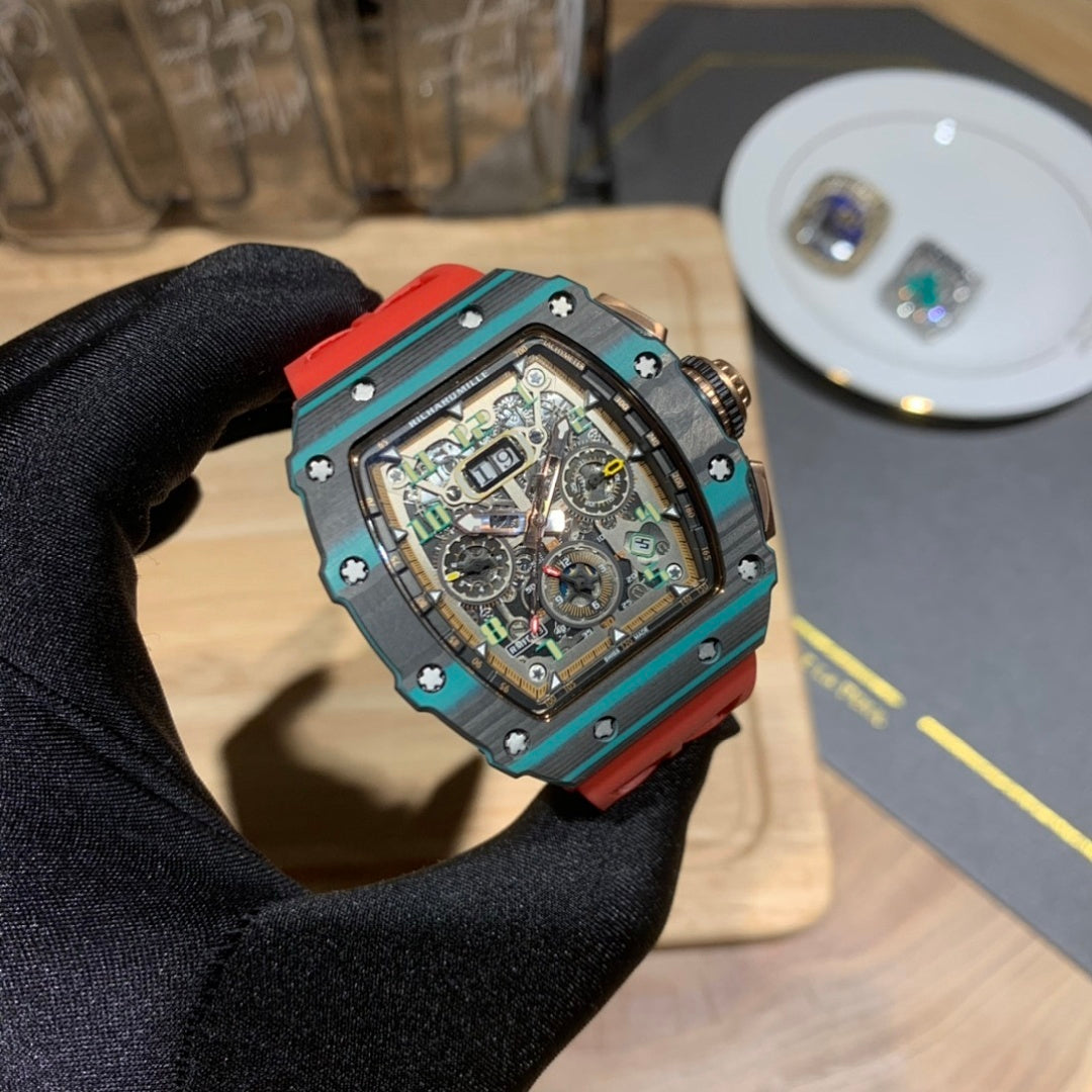 Richard Mille watch close-up in hand: teal case with red strap, skeleton dial.