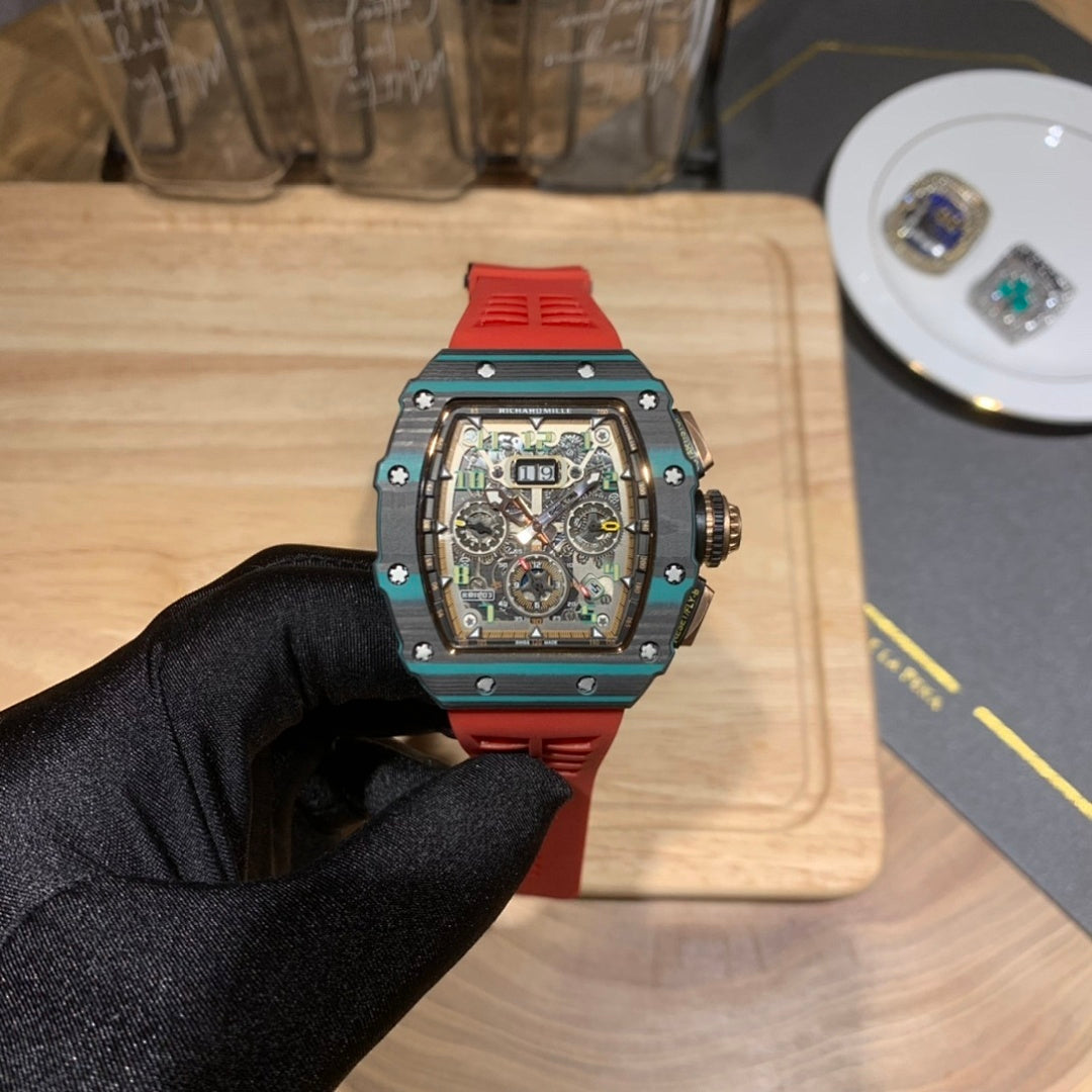 Richard Mille watch front view: teal and red case with skeleton dial on red strap.