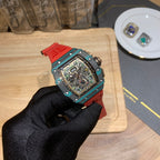 Richard Mille watch angled view: teal bezel, red strap, skeleton movement dial.