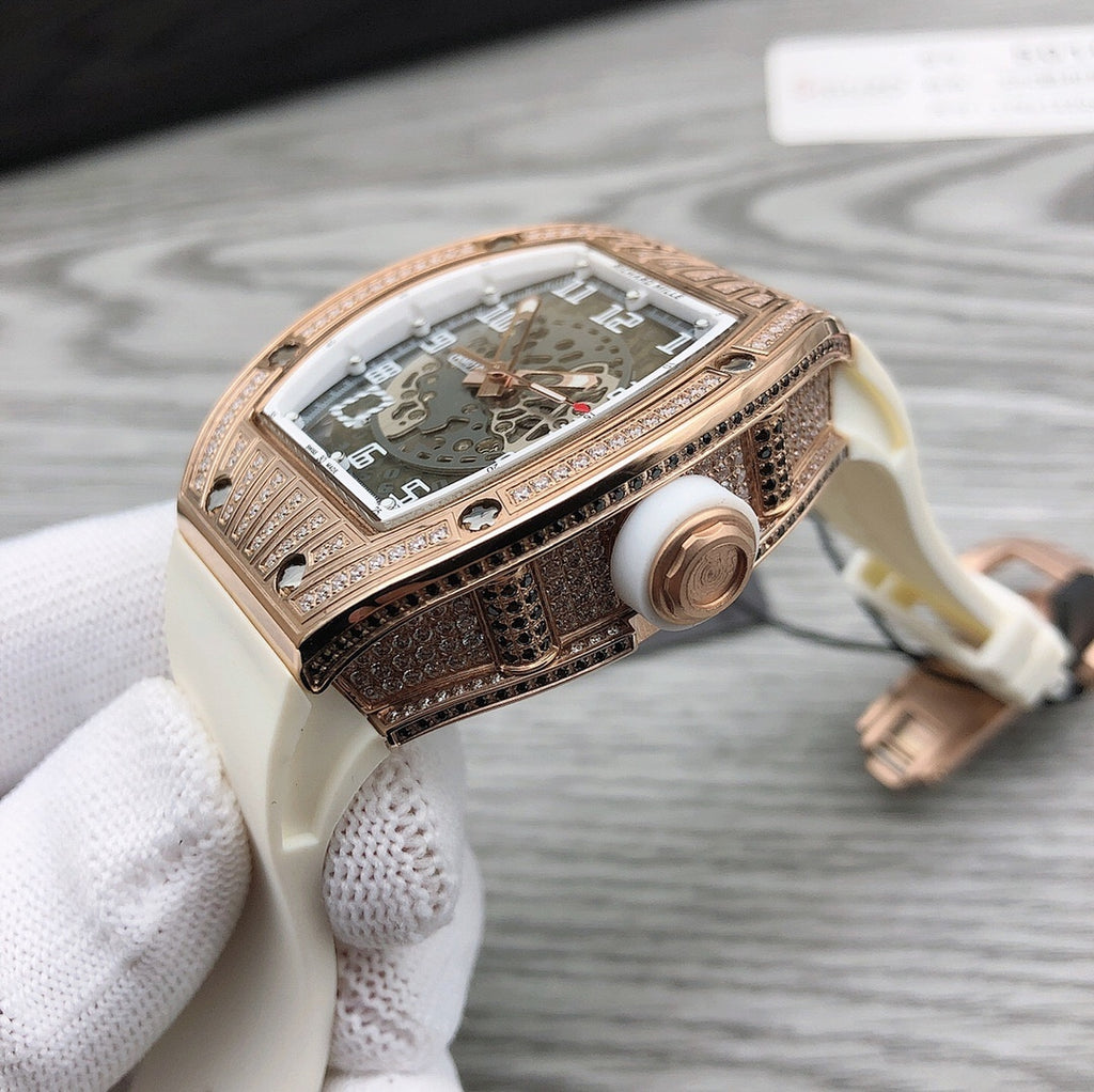 Rose-gold tonneau watch side profile with crown on white rubber strap