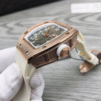 Rose-gold tonneau watch side profile with crown on white rubber strap