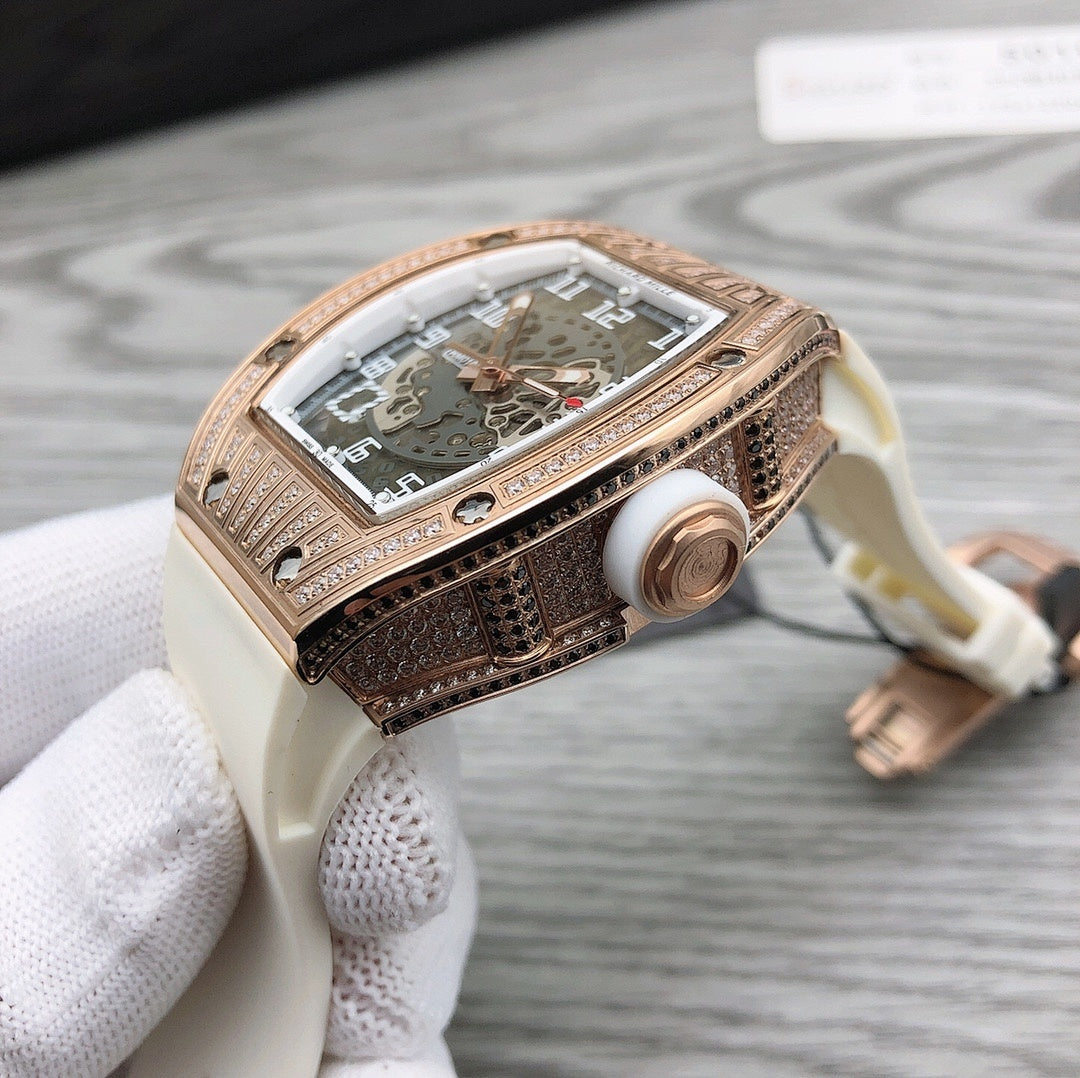 Rose-gold tonneau watch side profile with crown on white rubber strap
