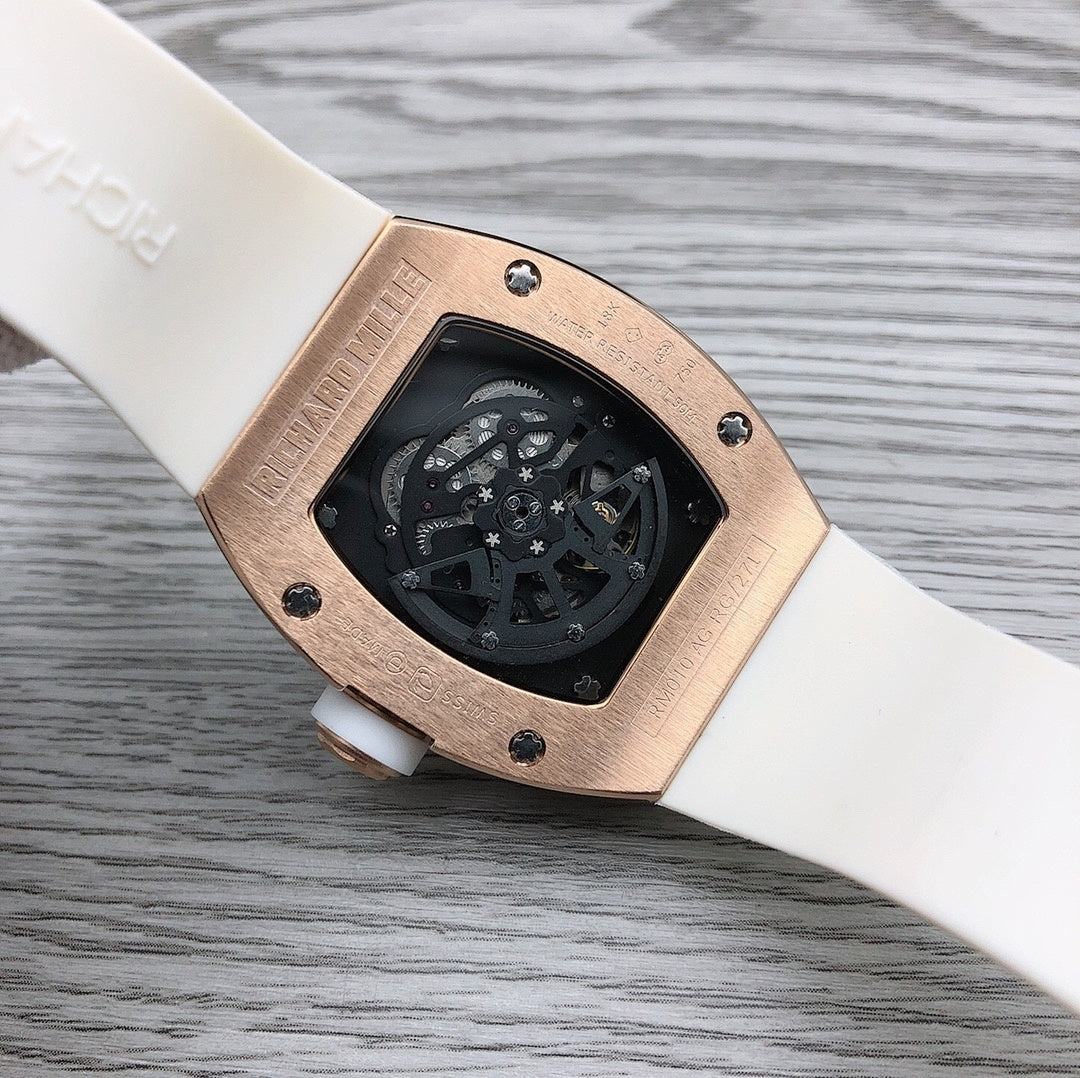 Rose-gold tonneau watch caseback on white strap with screws