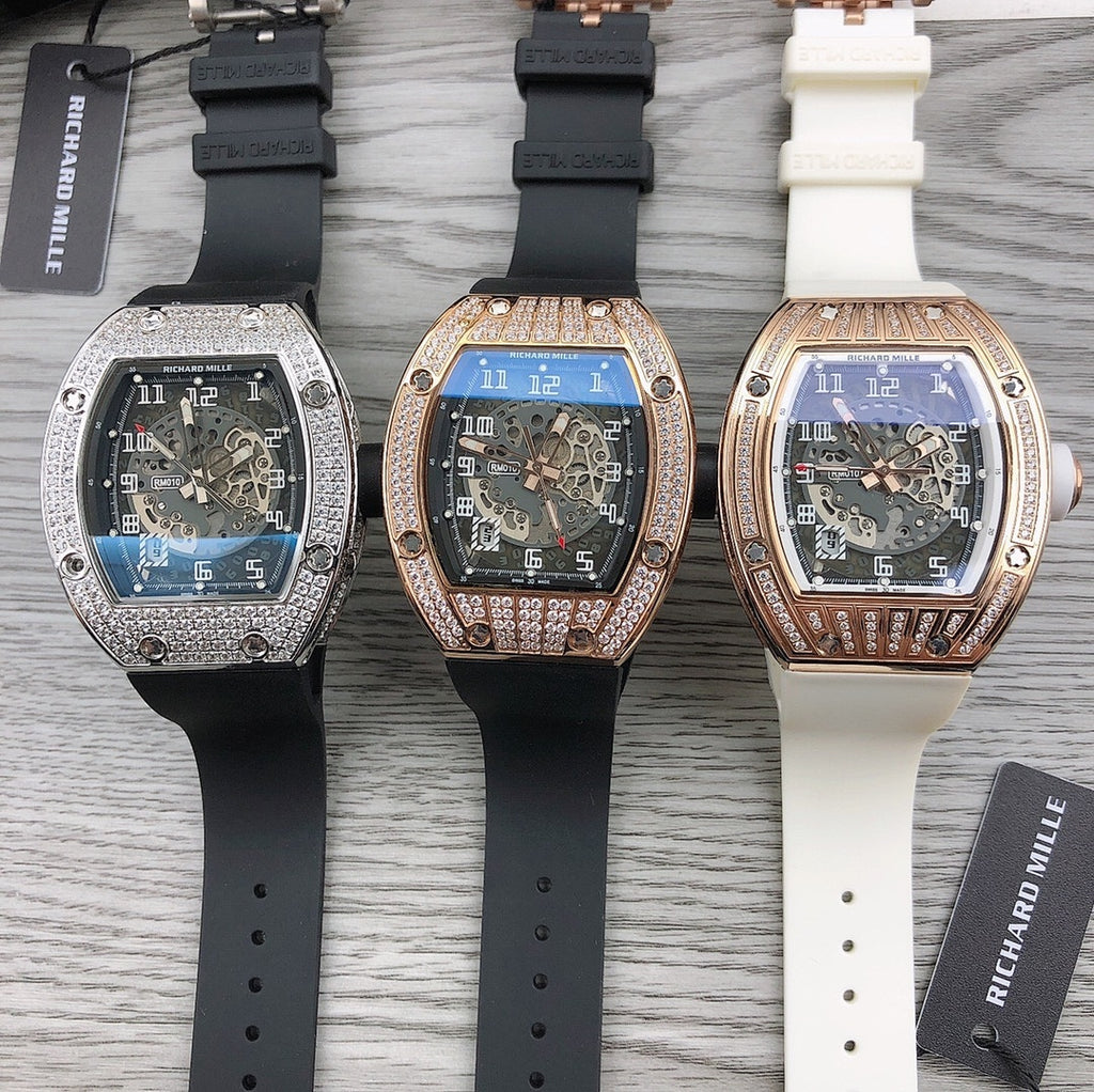 Three tonneau watches with black and white rubber straps, diamond bezels