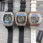 Three tonneau watches with black and white rubber straps, diamond bezels