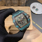 Richard Mille wristwatch close-up with teal bezel, black dial, and black rubber strap