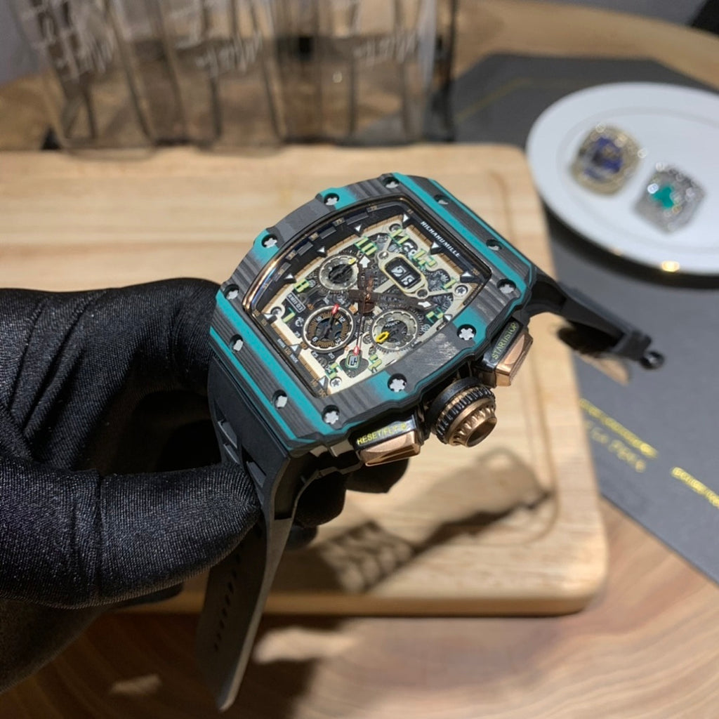 Richard Mille wristwatch side view showing teal bezel edges and black rubber strap