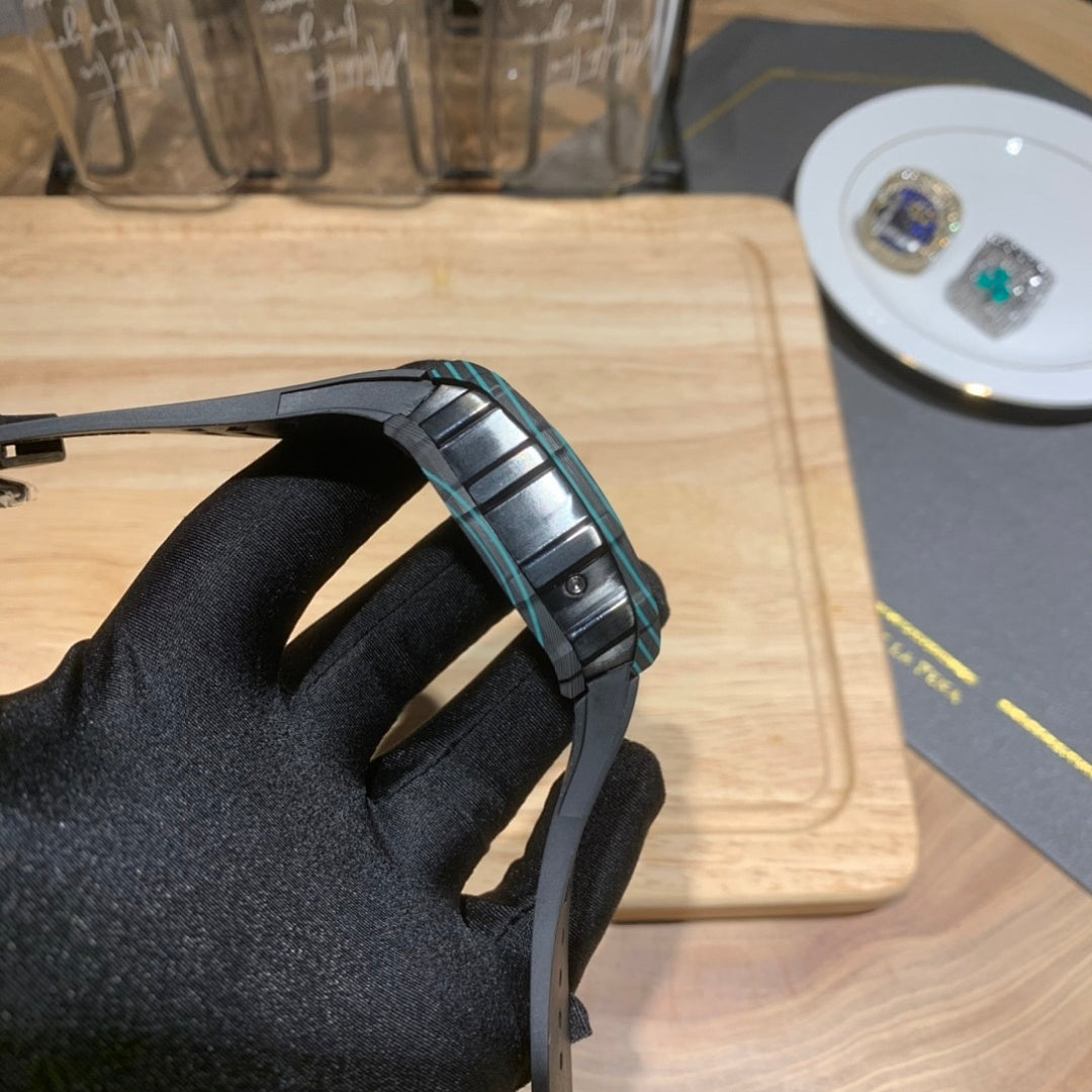 Richard Mille wristwatch close-up of black rubber strap with teal accents