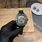 Richard Mille wristwatch front view with teal bezel, black dial, and black rubber strap