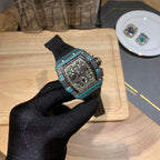 Richard Mille wristwatch angled view with teal bezel, black dial, and black rubber strap