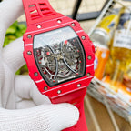 Richard Mille wristwatch with red case accents and see-through skeleton dial, red strap.