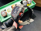Richard Mille watch side view with crown and orange accents on black rubber strap